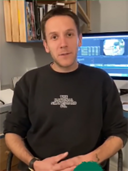 Ryan Gray sits in a sweatshirt with a computer screen behind him.